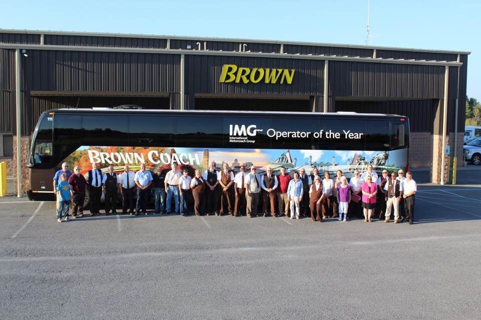 Brown Coach staff standing in front of a Brown Coach bus